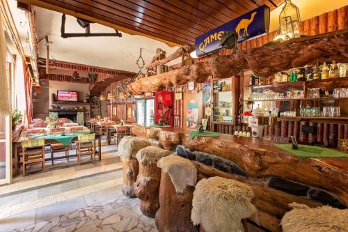 a restaurant with a bar with logs and tables at Chata Barborka in Horní Bečva