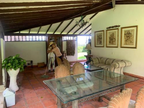 un homme debout dans un salon avec une table dans l'établissement Finca Hotel El Juncal, à Venecia