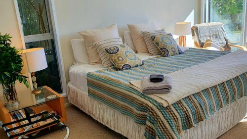 a bedroom with a bed with pillows and a window at Stillpoint Retreat in Motungarara