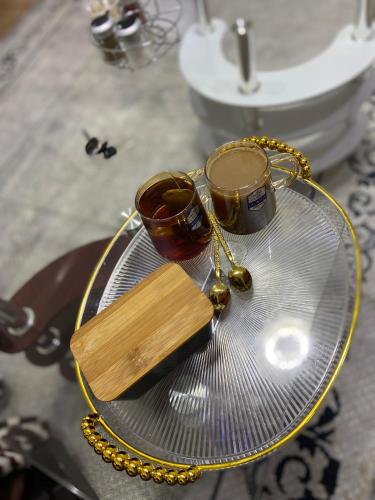 un tavolo di vetro con due tazze e una collana di Terus by Ree a Nanyuki