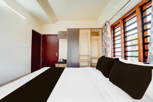 a bedroom with a bed and a large window at Townhouse Kalady Near Airport in Cochin
