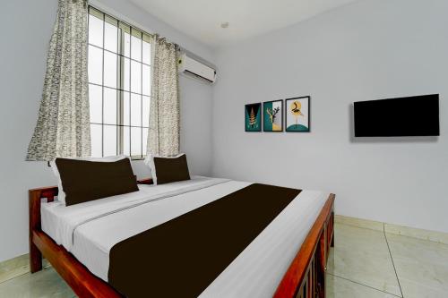 een slaapkamer met een groot bed in een kamer bij Super Hotel O Pukkattupady Aluva East in Cochin