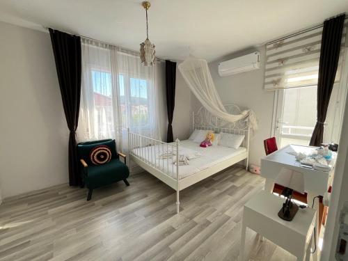 a small bedroom with a white bed and a chair at Villa with private pool in Alaçatı in Ilıca
