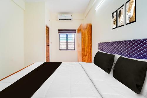 Giường trong phòng chung tại Hotel O HMT Colony Kochi Formerly Pullans Arcade