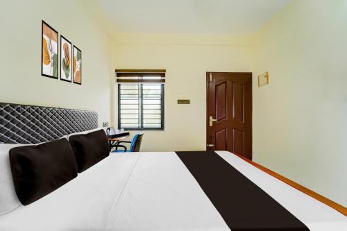 Giường trong phòng chung tại Hotel O HMT Colony Kochi Formerly Pullans Arcade