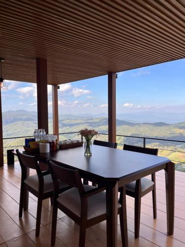 einen Esstisch und Stühle in einem Zimmer mit Aussicht in der Unterkunft La Villa Hill-ลาวิลล่าฮิลล์ in Mon Jam