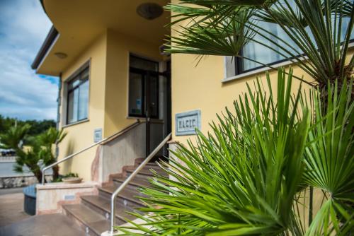 a yellow house with stairs and a palm tree at Magic Hotel in Atena Lucana