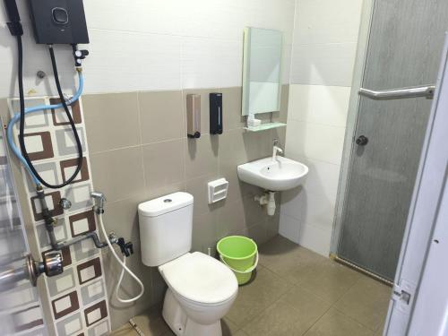 a small bathroom with a toilet and a sink at NAFIZ Pool Homestay Melaka - Fully AC 4 Rooms with 3 Toilets, PS4 in Kampong Alor