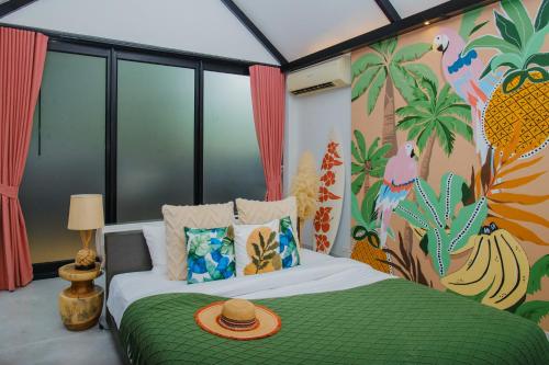 a bedroom with a green bed with a tropical mural at Tolani Resort Koh Samui in Lamai