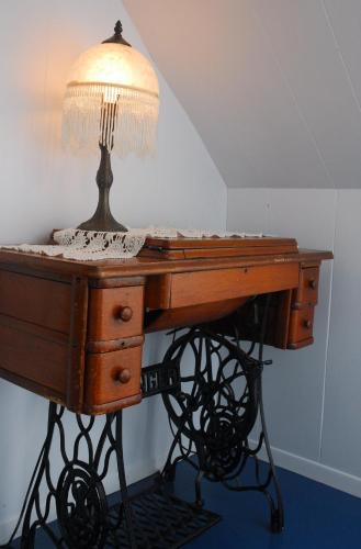 a desk with a lamp on top of it at Maison de campagne le Nichouette in Les Éboulements