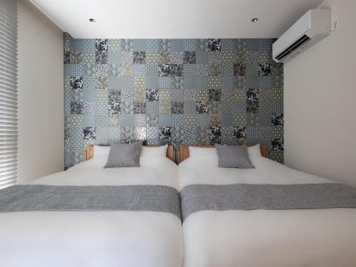 a bedroom with two beds and a wall at -new-SHELL THE THIRD in Kamakura