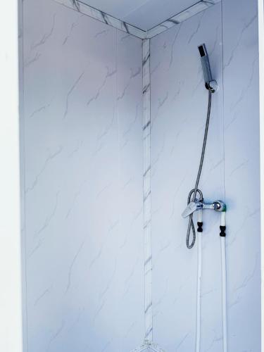a shower in a bathroom with white marble walls at Nawesa Resort in Eton