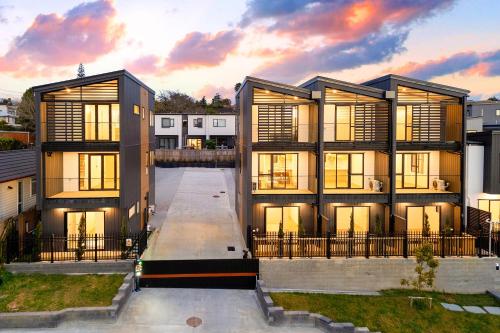 ein großes Gebäude mit Sonnenuntergang im Hintergrund in der Unterkunft Glen Eden Haven in Auckland