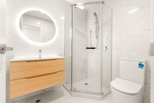 a bathroom with a shower and a toilet and a sink at Modern 3BR Family Townhouse & Walk to Train & Free Parking & Gated Community in Auckland