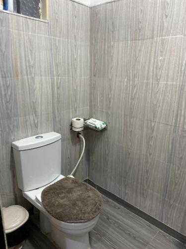 ein Badezimmer mit weißer Toilette und Holzboden in der Unterkunft Teru in Nanyuki