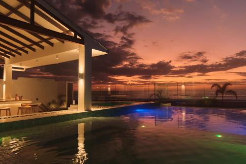 een zwembad met een zonsondergang op de achtergrond bij Alesea Baroro, La Union, Private Modern Villa with Pool, Jacuzzi, Beachfront View in Balio