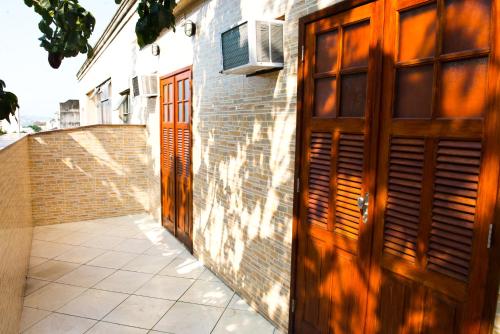 an alley with wooden doors on a brick building at Orange - Casa de Hóspedes - modelo Pousada in Rio de Janeiro