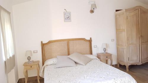 ピアーノ・デッレ・ピエーヴェにあるIl Gelso Assisiのベッドルーム1室(ベッド1台、ナイトスタンド2台、ランプ2つ付)