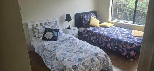 a bedroom with two beds and a bedskirts at HolidaysHouse Close to Melbourne in Truganina