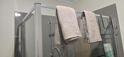 a bathroom with a shower and towels on a rack at HolidaysHouse Close to Melbourne in Truganina