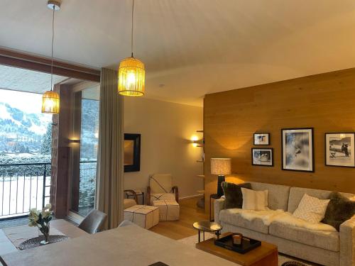 a living room with a couch and a large window at Winklern Lodges in Kitzbühel
