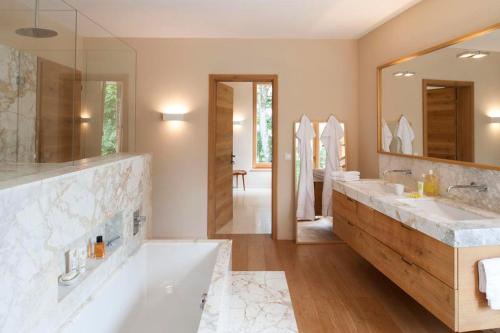 a bathroom with two sinks and a large mirror at Winklern Lodges in Kitzbühel