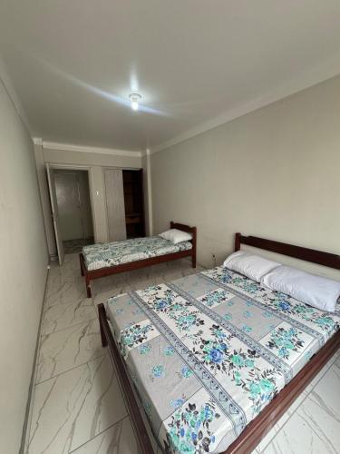 two beds sitting in a room with at Casa para até 8 pessoas perto da Basílica in Aparecida