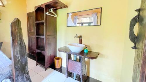 a bathroom with a sink and a mirror at Sumatra Cheeky Monkeys in Bukit Lawang