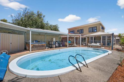 a large swimming pool in front of a house at Coastal 2-Bed Home with Pool in Safety Bay