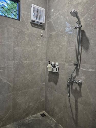 a bathroom with a shower with a glass door at A Calm Spacious Cottage with Mount Agung View in Selat