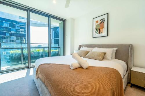 a bedroom with a bed and a large window at 1BR Queens Wharf City Charm with Balcony Views - LV 15 in Brisbane