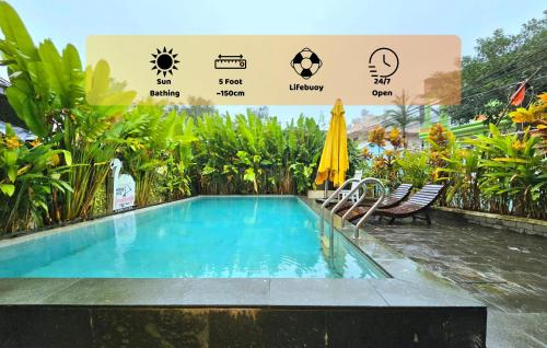 una piscina in un resort con ombrellone e sedie di Flamingo Homestay - Spacious Room with Comfortable Spring Mattress - 200m from Hoi An Ancient Town & Night Market a Hoi An