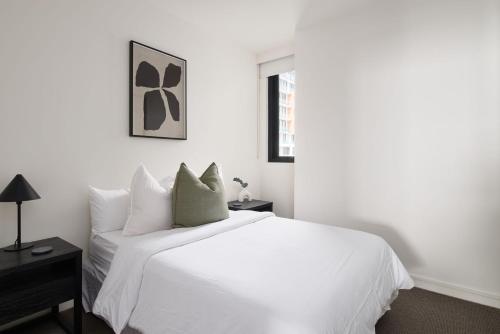 a white bedroom with a white bed and a window at The Outlook in Newcastle