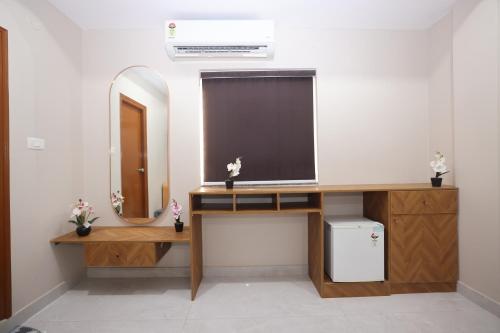 a bathroom with a desk with a mirror and a sink at Hotel Qualia Oak in Hyderabad