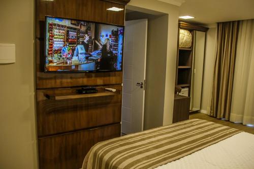 a hotel room with a bed and a flat screen tv at Hotel Gramado Interlaken in Gramado