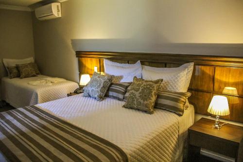 a hotel room with two beds and two lamps at Hotel Gramado Interlaken in Gramado