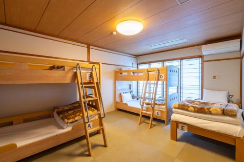 deux lits superposés dans une pièce avec une chambre dans l'établissement Guest House Ouka, à Takayama