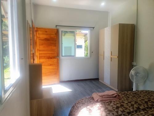een slaapkamer met een bed, een raam en een deur bij Koh kood Good Time by Jasmine in Ko Kood