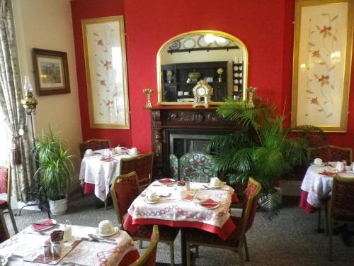 a dining room with two tables and a fireplace at Balmoral in Skegness
