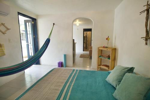 een slaapkamer met een bed en een hangmat. bij Casa Nido Bacalar in Bacalar