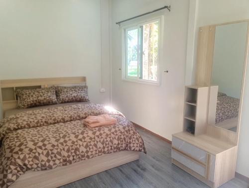 ein Schlafzimmer mit einem Bett und einem großen Spiegel in der Unterkunft Koh kood Good Time by Jasmine in Ko Kood