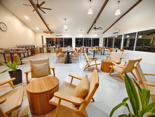 un restaurant avec des chaises, des tables et des tables dans l'établissement Borneo Nature Lodge 2, à Kinabatangan