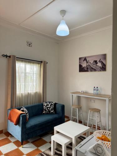 een woonkamer met een bank en een tafel bij Lion Hill Place in Nakuru