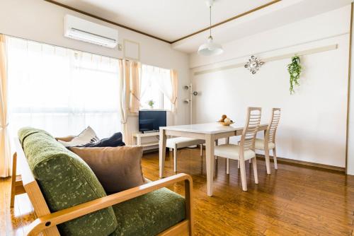 a living room with a green couch and a table at Universal Bay Condominium in Osaka