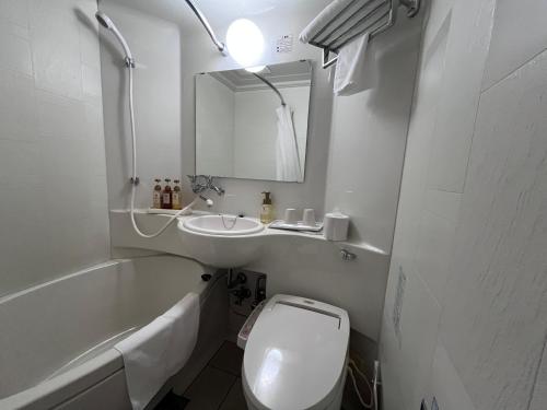 een badkamer met toilet, wastafel en bad bij Urbain Hiroshima Executive in Hiroshima