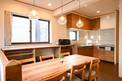 a kitchen with a wooden table and chairs at Lodge Urawa in Saitama