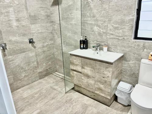 a bathroom with a shower and a sink and a toilet at Hichinbrook Lodge, waterfront in Cardwell
