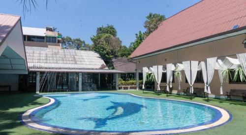 een zwembad in een tuin naast een gebouw bij Banna Resort in Ban Khlong Kadon (1)