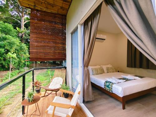 une chambre avec un lit et un balcon dans l'établissement Borneo Nature Lodge 2, à Kinabatangan