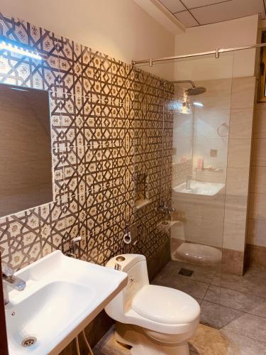 a bathroom with a toilet and a sink and a shower at Hotel pearlinn karachi in Karachi